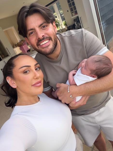 Sophie Kasaei poses with her partner and newborn, showing off her flat stomach.