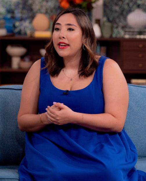 Michelle Elman wearing a blue dress and sitting on a blue sofa during the "This Morning" TV show.