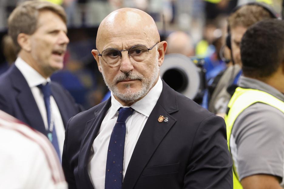 A man in a suit, eyeglasses, and a beard watching the France v Spain semi-final at the FIFA World Cup 2026.