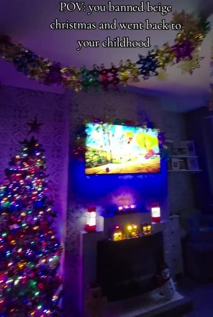 POV: A brightly decorated room with a lit Christmas tree and colorful garland on the ceiling.
