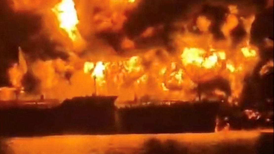 A ship burns, after Iranian explosive-laden boats appear to have attacked two fuel tankers in Iraqi waters setting them ablaze