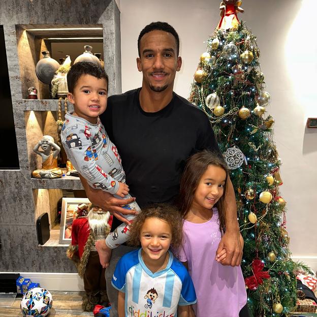 Scott Sinclair with Matilda, Delilah and Charlie in front of a Christmas tree.