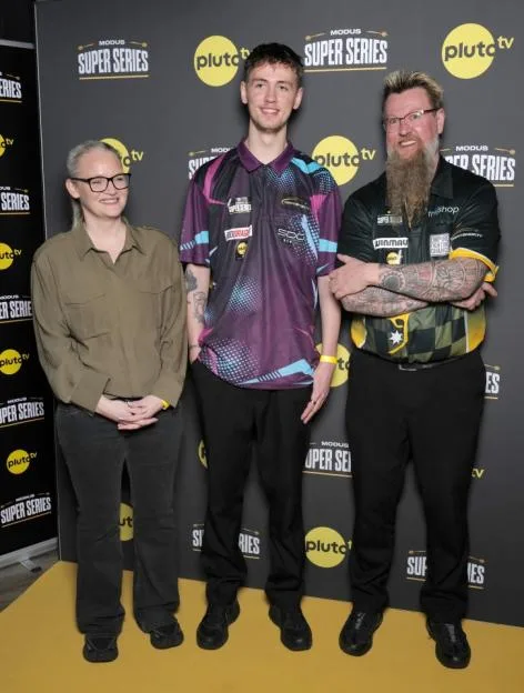 Laura Turner, Mason Whitlock and Simon Whitlock stand smiling in front of a Pluto TV and Modus Super Series branded backdrop.