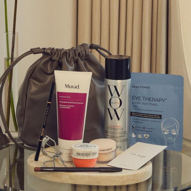 An assortment of beauty products including Murad cleanser, Color Wow spray, MAC eyeliner, Laura Mercier powder, and an under-eye mask.