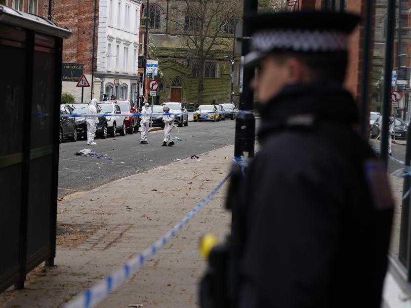 Crime scene investigators examine a street with police tape after a car strike in Derby, United Kingdom.