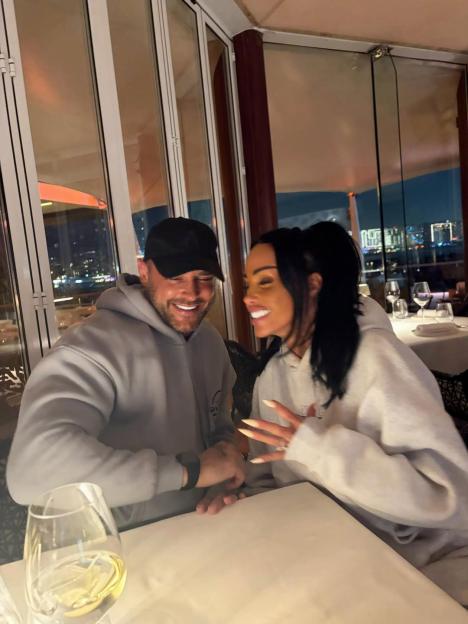 Katie Price and Andrew Lee smiling at each other at a restaurant.