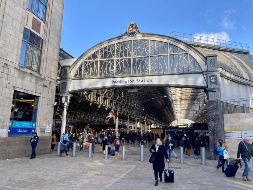 Exterior view of Paddington Railway Station with people entering and exiting.