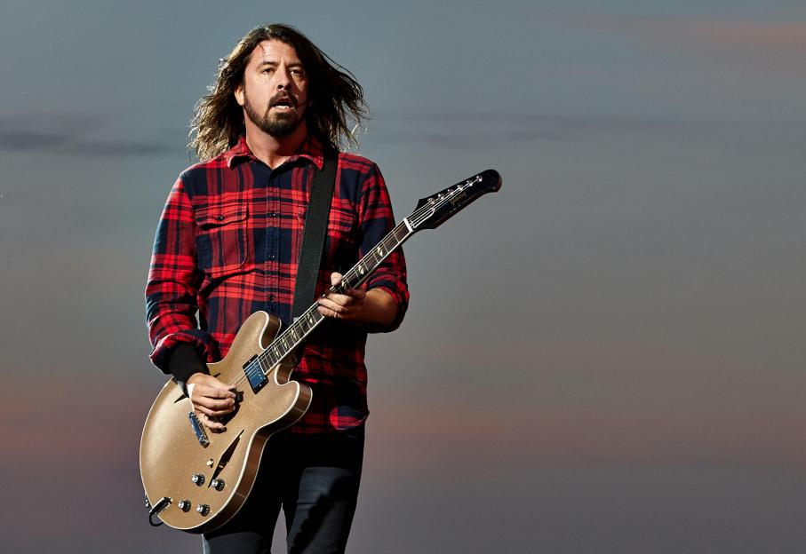 Dave Grohl playing guitar and singing on stage.