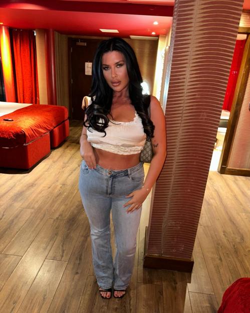 Holly Louise Ditchfield posing in an interior space with red accents.