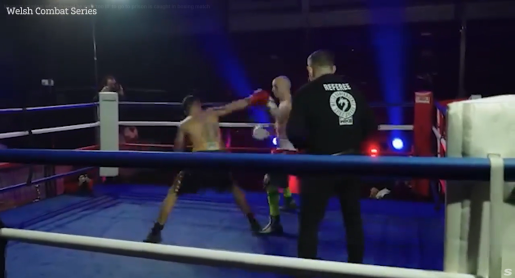 A boxing match with two fighters in the ring, with a referee watching in the foreground.
