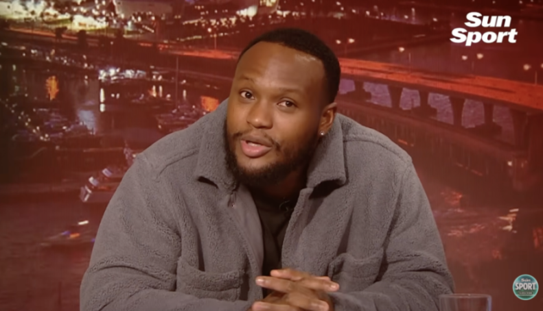 Man in grey fleece jacket speaking on Sun Sport.