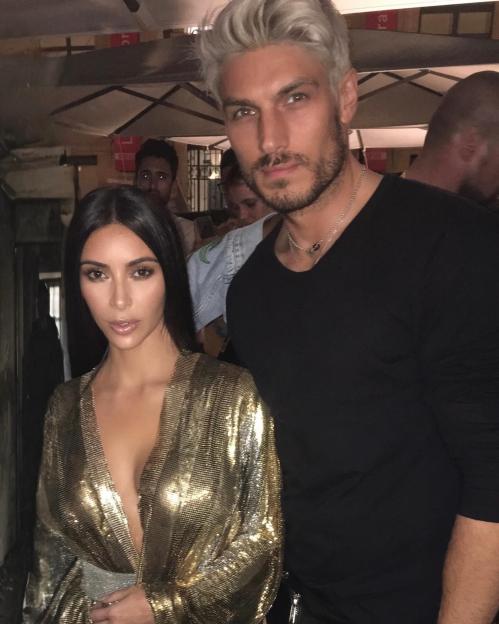 Kim Kardashian in a gold chainmail top next to Chris Appleton with blond hair.