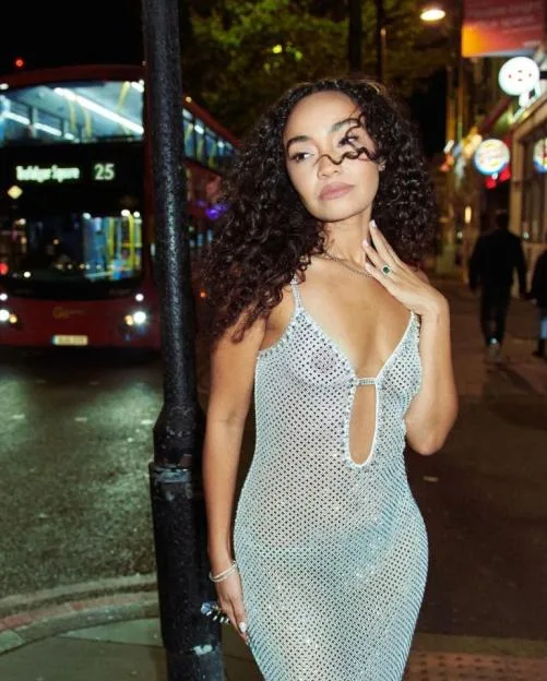 Leigh-Anne Pinnock poses in a sparkly dress on a city street at night.