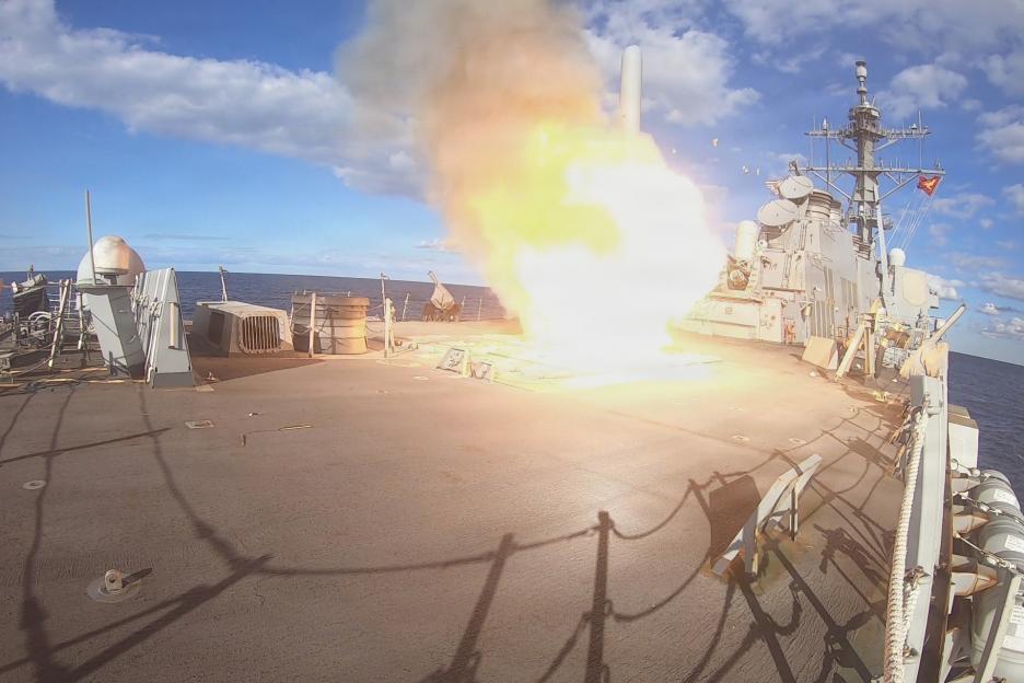 The USS Winston S. Churchill guided-missile destroyer launching a Tomahawk missile with a fiery exhaust plume.