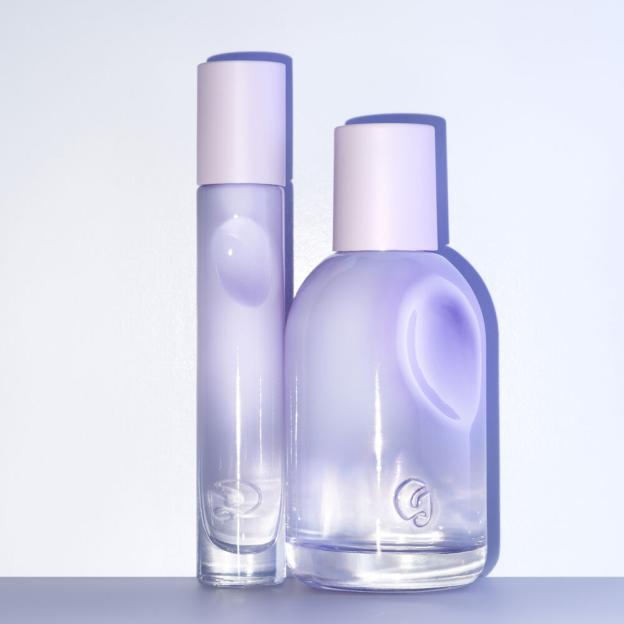 Two perfume bottles with lavender liquid and light pink caps on a light background.
