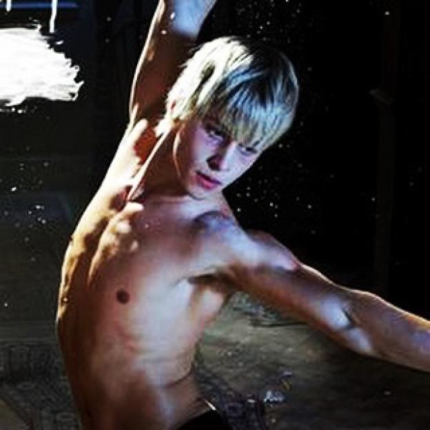 Mitch Hewer as Maxxie, shirtless and looking upwards.