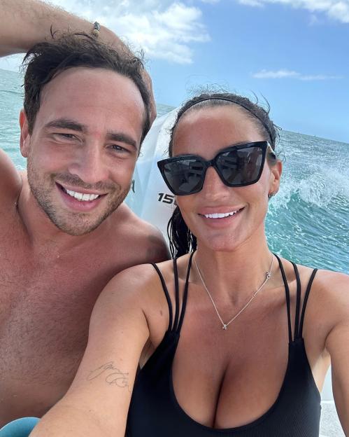 Danny Cipriani and Victoria Rose on a boat with water splashing in the background.