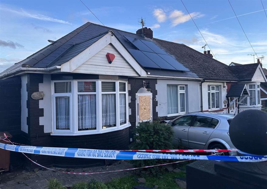A silver car crashed into a house with a police cordon.