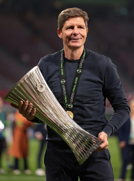 Man holding the UEFA Europa Conference League trophy and wearing a medal for the Leipzig Final 2026.