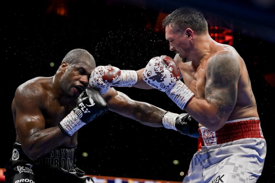 Oleksandr Usyk punches Daniel Dubois in a heavyweight boxing title fight.