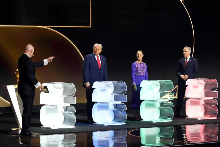 U.S. President Donald Trump stands next to Mexico City's Mayor Claudia Sheinbaum and Edmonton's Mayor Don Iveson as a man in a suit points to the left.