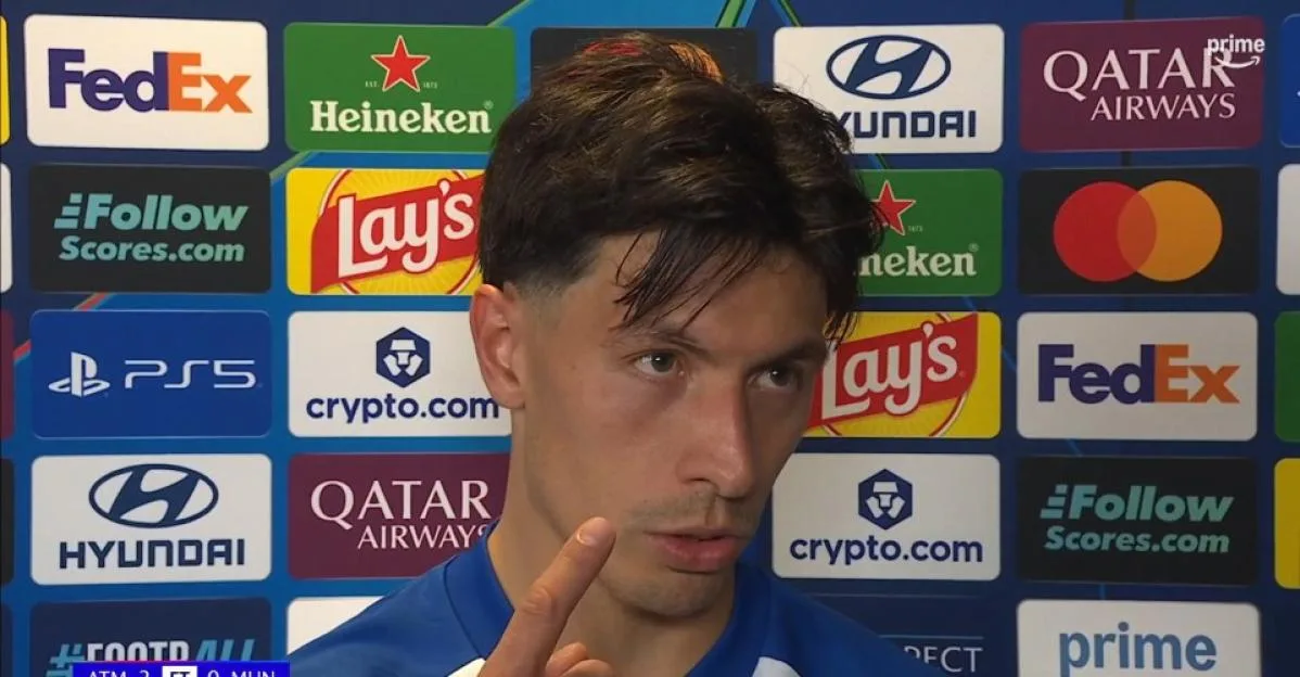 Lisandro Martinez standing in front of a sponsor backdrop.