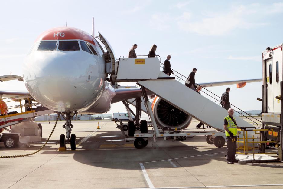Passengers disembarking an Easyjet airplane via stairs at Bristol Airport.