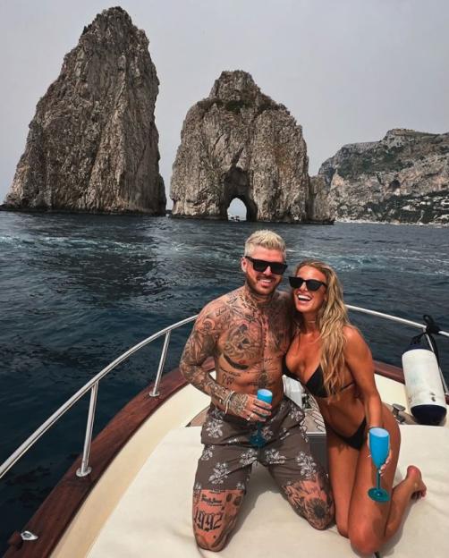 Sam Reece and his fianceé on a boat with rock formations in the background.