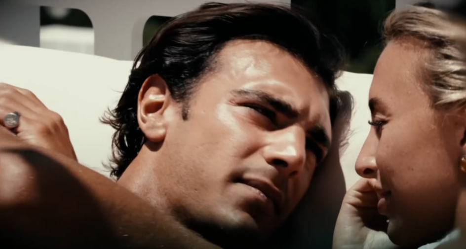 A man and woman laying down, looking at each other.