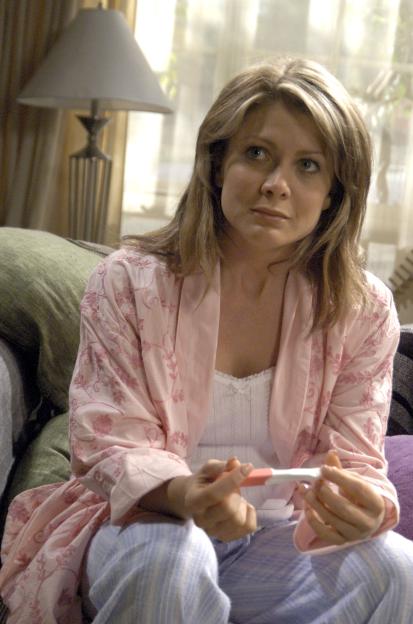 Natalie Bassingthwaighte in character as a woman looking at a positive pregnancy test.