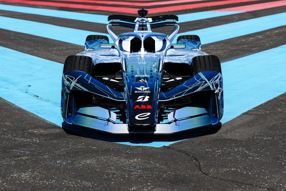 The front view of the Formula E Gen4 electric race car on a racetrack.