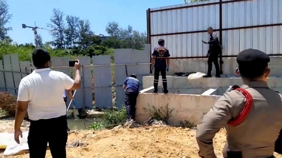 Police investigate a canal next to a construction site.