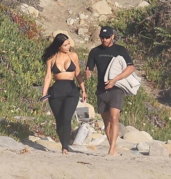 Kim Kardashian and Lewis Hamilton walking together on a beach in Malibu.