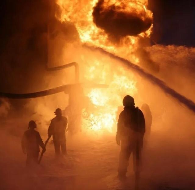 Ukrainian firefighters battling a massive fire and smoke.