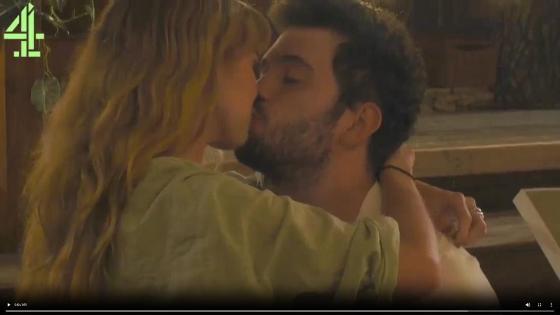 A blonde woman and a bearded man kissing intimately.