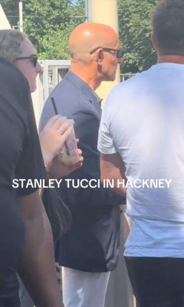 Stanley Tucci at a London train station with commuters.