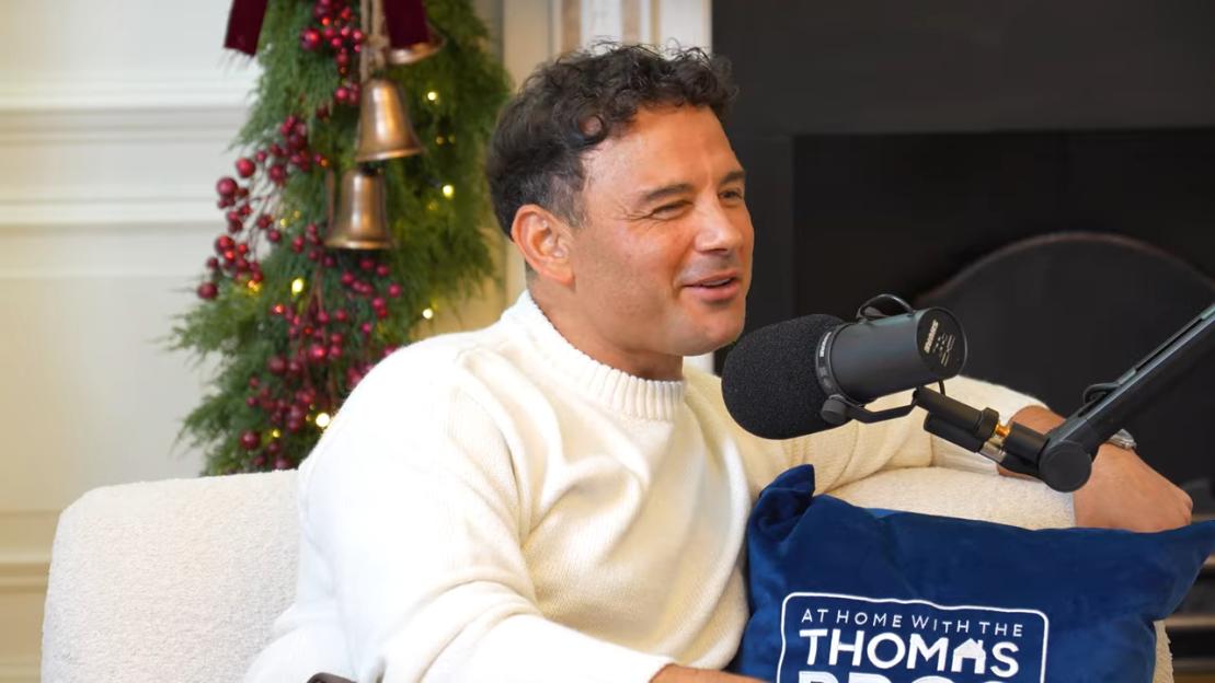 Ryan Thomas on a podcast with a holiday wreath in the background.