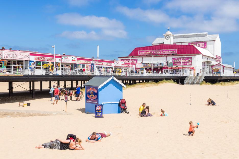 Britannia Pier and Theatre in Great Yarmouth with amusement arcades, donkey rides, and families on the beach.