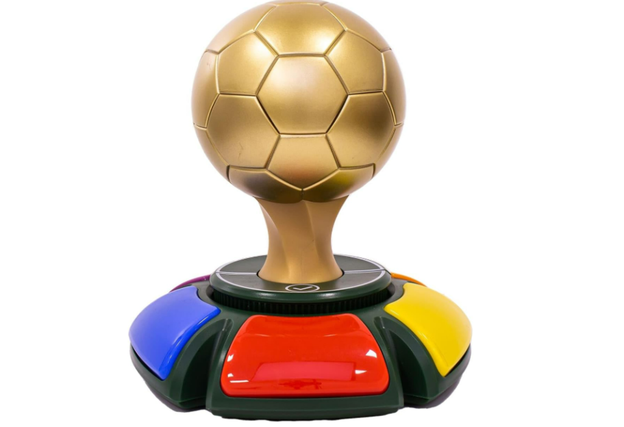 A game console with a gold football-shaped top and colorful buttons on the base.
