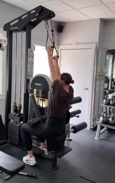 Maria Sharapova training with a pull-down machine in a gym.