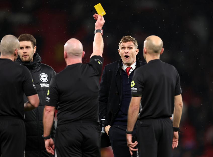 Referee Simon Hooper shows Manchester United Interim Manager Darren Fletcher a yellow card.