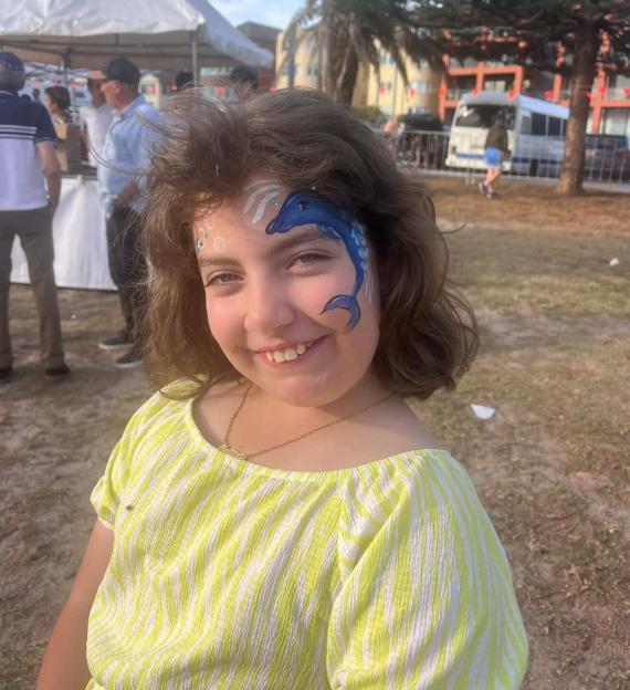 Matilda Bee Britvan with a blue dolphin painted on her face.