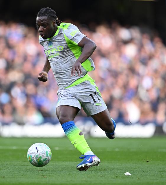 Manchester City manager Pep Guardiola stands on the pitch.