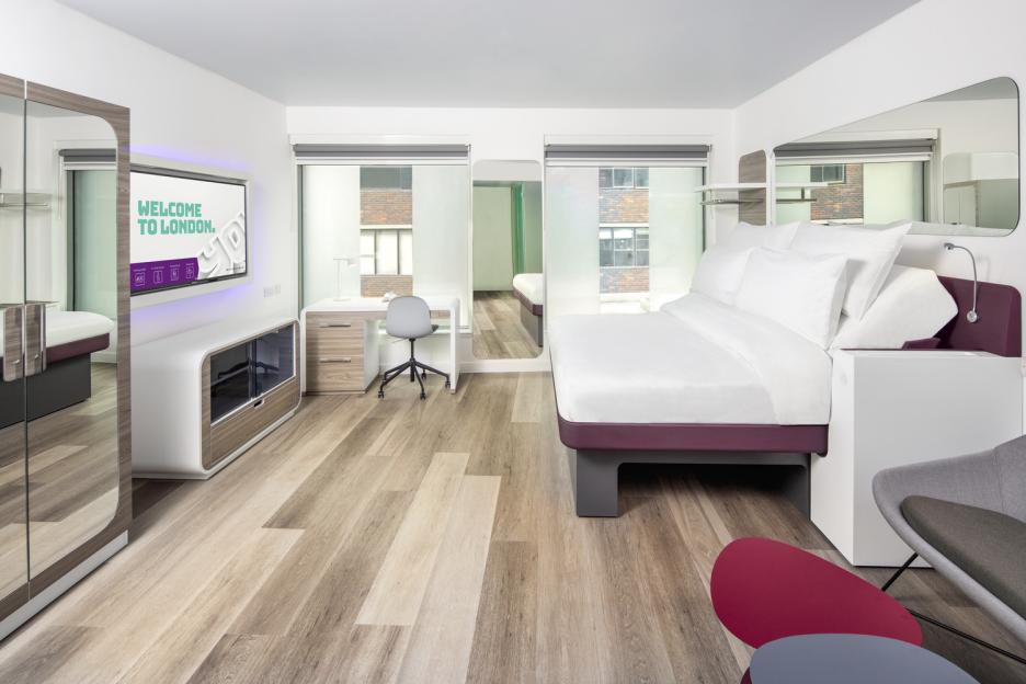 Yotel Clerkenwell London hotel room with bed, desk, and welcome screen.