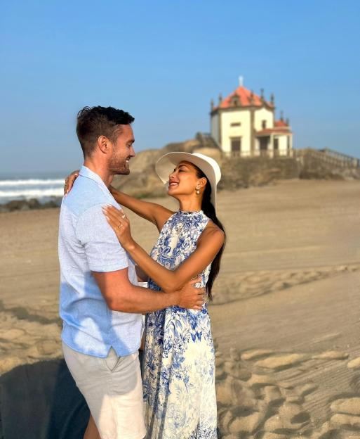 Nicole Scherzinger and Thom Evans embrace on a beach.