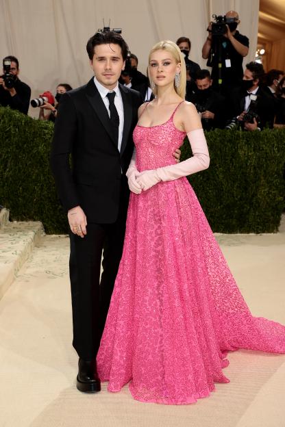 Brooklyn Beckham in a black tuxedo and Nicola Peltz in a pink Valentino gown and gloves at the Met Gala.