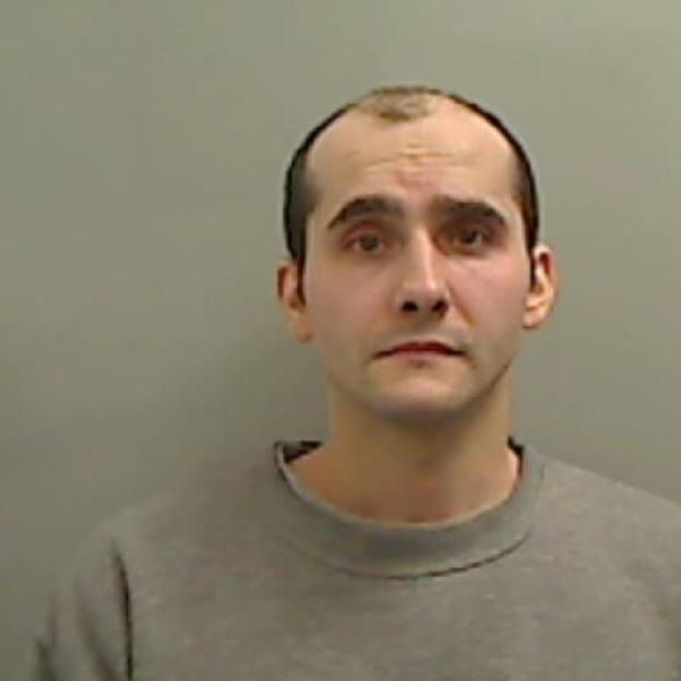 Man with receding hairline and dark eyes.