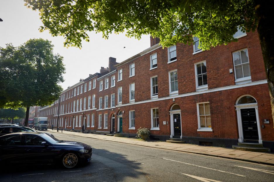A row of Georgian terraced brick buildings on St John Street in central Manchester.