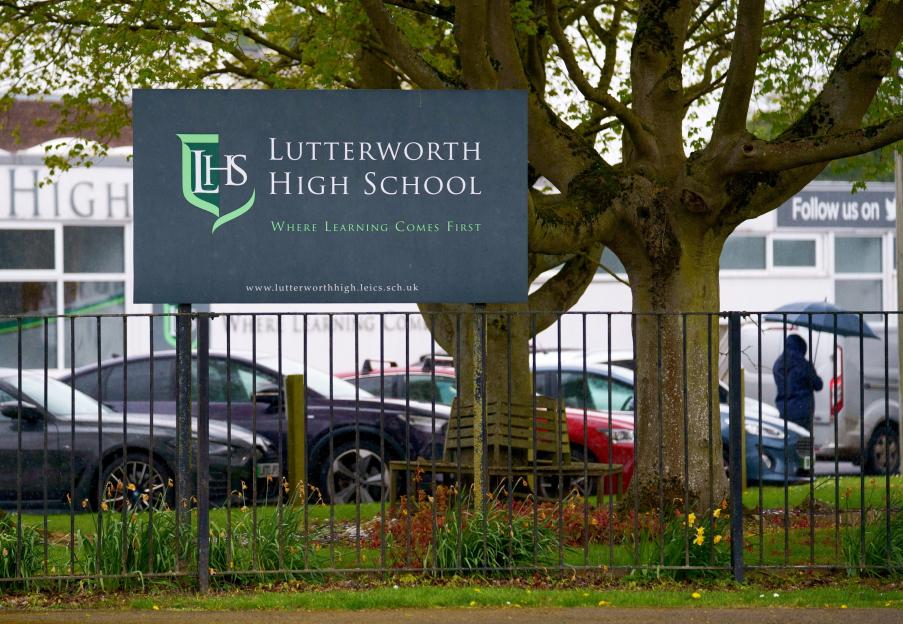 Lutterworth High School sign in front of trees and a black fence.