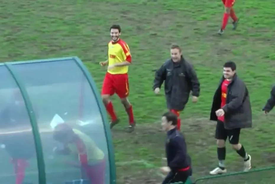 Footballer running and headbutting the dugout.